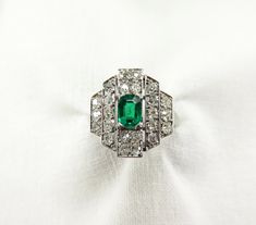 "Circa 1930. Art Deco Gorgeousness. A very lovely green indeed. A prong set, mixed cushion cut 0.45ctw emerald is accented by 24 sparkling bead set round single cut diamonds in a linear art deco platinum setting. I love how the central rectangle step sits slightly above the tapering side steps which gives a nice dimension to the setting. The bit of negative space, which I think is often under appreciated in deco rings, is such a great design detail. After all, the setting is the foundation of be Under Appreciated, 1930 Art, Deco Rings, Linear Art, Diamond Platinum Ring, Amethyst And Diamond Ring, Platinum Diamond Rings, Bead Set, Diamond Flower