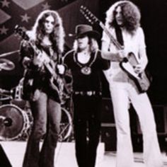 three women are standing on stage with guitars in their hands and one woman is holding an electric guitar