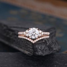 a close up of a diamond ring on a rock