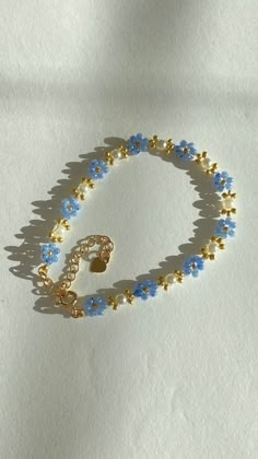 a blue and gold beaded bracelet on a white surface