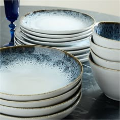 a stack of white and blue dishes sitting on top of a table