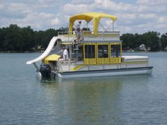 a yellow and white boat with a slide in the middle of it's water