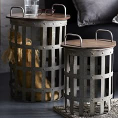 two metal baskets sitting next to each other on top of a rug in front of a couch