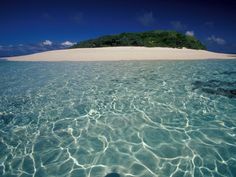 an island in the middle of clear water