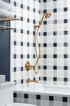 a bathroom with blue and white tiles on the walls, shower head, and hand rail