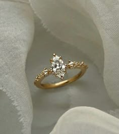 a close up view of a diamond ring on white fabric