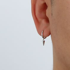 a close up of a person with ear piercings on their ears and behind them is a white wall