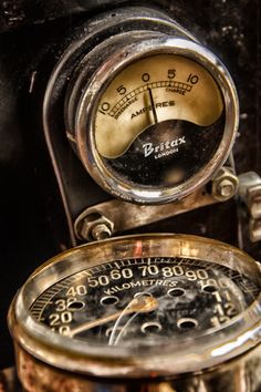 an old time clock sitting on top of a wooden table next to a metal object