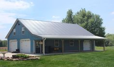 a large blue barn with two garages on the front and one attached to it