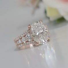 a close up of a ring on a table with flowers in the background