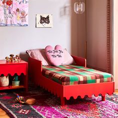 a child's bedroom with pink and green accents, including a red daybed