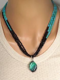 The necklace is made of 30mm green - black agate pendant, and green and black small beads, triple strand. A length is 18'' - 20''(45cm - 50cm). Your jewelry is ready to ship. Thank you for visiting my shop. Black Agate Beaded Necklace With Natural Stones, Handmade Black Turquoise Necklace With Round Beads, Black Onyx Pendant Beaded Necklace, Bohemian Black Gemstone Beads, Black Beaded Necklaces With Polished Pendant, Black Beaded Necklace With Gemstone Pendant, Black Beaded Necklace With Polished Pendant, Handmade Black Agate Beaded Necklaces, Black Polished Pendant Beaded Necklaces