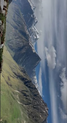 the view from an airplane looking down at mountains and clouds