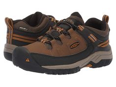 KEEN Kids Targhee Low WP (Little Kid/Big Kid) - Boy's Shoes : Dark Earth/Golden Brown : Hike from mountain-to-mountain with savvy gear by sporting the durable Keen Kids Targhee Low WP Hiking shoe. Sturdy hiking shoe is constructed in a waterproof leather upper with KEEN.Dry finish and breathable mesh underlays featuring Cleansport NXT technology to naturally control unwanted odors. Robust sneaker is constructed with a protective toe bumper, bungee laces with a toggle closure, and an adjustable a Sporty Waterproof Walking Shoes With Round Toe, Rugged Sports Hiking Boots, Rugged Impact-resistant Hiking Boots For Sports, Rugged Impact Resistant Hiking Boots For Sports, Impact Resistant Rugged Hiking Boots For Sports, Sporty Brown Gore-tex Sneakers, Brown Breathable Sports Walking Shoes, Brown Gore-tex Sporty Walking Shoes, Sporty Brown Gore-tex Walking Shoes