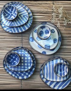 four blue and white plates sitting on top of a bamboo mat