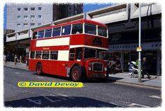 a double decker bus is parked on the side of the road in front of a building