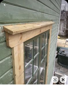 a wooden window frame on the side of a house