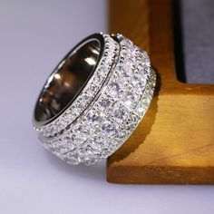 a diamond ring sitting on top of a wooden stand