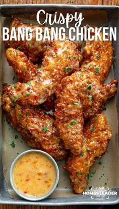 chicken wings with sauce in a pan on a wooden table and text overlay that reads, crispy bang bang chicken