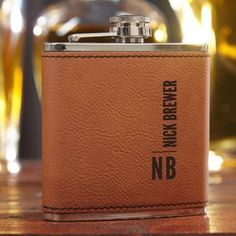 a brown leather flask with the name nb on it sitting on a table