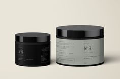 two black and white jars with labels next to each other on a gray surface,