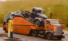 an orange tow truck with two green trucks on it's flatbed and one yellow car