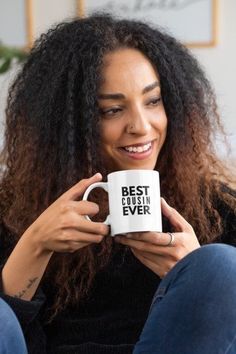 a woman sitting on a couch holding a coffee mug with the words love written on it