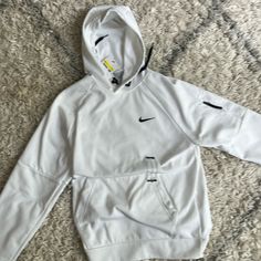 Nike Therma-Fit White Functional Hoodie For Light Sports, Functional White Hoodie For Sports Season, White Functional Moisture-wicking Hoodie, White Moisture-wicking Functional Hoodie, White Moisture-wicking Hoodie, Functional White Moisture-wicking Hoodie, Nike Functional Sweatshirt With Adjustable Hood, Functional Nike Hoodie For Streetwear, Nike Winter Hoodie For Light Sports