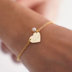 Elevate your style with our Personalized Heart Bracelet! Handcrafted with real pearls, this elegant bracelet is the perfect gift for her on any occasion. Whether it's a birthday, anniversary, or Christmas, this Name Bangle Bracelet adds a touch of sophistication to any outfit. This Name Engraved Bracelet for Mom features a delicate heart charm, adding a sentimental touch to your gift. Personalize it with your loved one's name for a truly special touch. Key Features: * Bracelet measures 16mm * Ma Heart-shaped Pearl Bracelet For Wedding, Elegant Beaded Bracelet With Heart Charm For Valentine's Day, Heart-shaped Pearl Bracelet With Charm For Wedding, Elegant Heart-shaped Charm Bracelet For Weddings, Elegant Wedding Charm Bracelet With Heart Charm, Adjustable Pearl Bracelets With Heart Charm, Heart-shaped Pearl Charm Bracelet For Wedding, Pearl Heart Bracelet Gift, Elegant Pearl Heart Bracelet With Charm