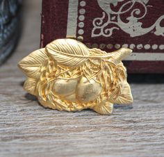 a gold brooch sitting on top of a wooden table