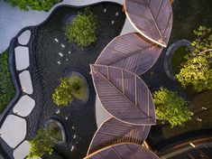 an aerial view of a garden with trees and water features in the center, surrounded by stone walkways