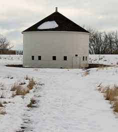 a snow covered field with a white building in the background