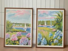 two framed paintings on the wall next to each other with boats in the water behind them