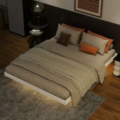 a bed sitting on top of a wooden floor next to a wall with pictures above it