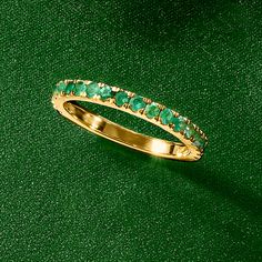 a gold ring with green stones on it