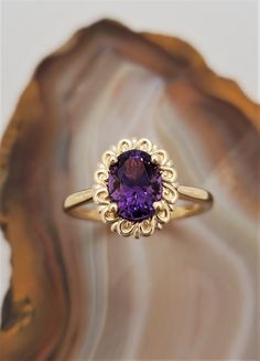 CJ124046OVAM Maine Amethyst ring. Royal purple Maine amethyst set in a beautiful 14k yellow gold solitaire ring with a scroll halo. Amethyst is 8x6mm, 1.2cts. The gemstone is from the 4th of July discovery in Deer Hill, Stow, Maine. Currently this ring is size 7, we will resize at no extra charge, please specify ring size at checkout if resizing is needed. Emerald Amethyst Ring, Gold Ring With Purple Stone, Amethyst Engagement Ring Gold, Amethyst Jewelry Ring, Amethyst Ring Gold, Vintage Amethyst Ring, Yellow Gold Amethyst Ring, Purple Stone Ring, Victorian Style Rings