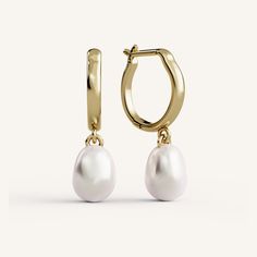 a pair of gold hoop earrings with white pearls on the front and back of each ear