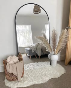 a room with a large mirror and some plants in the corner on the carpeted floor