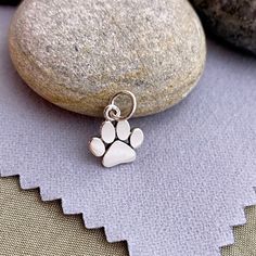 Darling Tiny Sterling Silver Paw Print Charm Dimensions: H: 1mm L: 13mm W: 9mm Length measurement includes the 5 mm soldered jump ring. Need a Chain? Cable: https://www.etsy.com/listing/882796685/14kt-gold-filled-or-925-sterling-silver? Box: https://www.etsy.com/listing/746309155/4kt-gold-filled-or-925-sterling-silver? Find more charms in my supply shop: ImprintedMemoriesToo.etsy.com Find complete ready to gift personalized jewelry in my main shop: ImprintedMemories.etsy.com Due to the small siz Small Charms Jewelry For Gifts, Small Charms Jewelry As A Gift, Hypoallergenic Sterling Silver Dog Tag Jewelry, Pendant Charms Jewelry For Best Friend Gift, Hypoallergenic Pendant Charm As A Gift, Hypoallergenic Pendant Charms For Gifts, Gold Sterling Silver Jewelry With Paw Print, Nickel Free Round Pendant Jewelry For Best Friend, Nickel-free Round Pendant Jewelry For Best Friend Gift