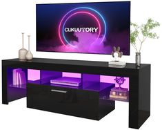 an entertainment center with a large television mounted on it's wall and purple lighting