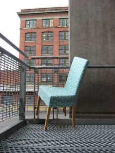 a blue chair sitting on top of a metal rail