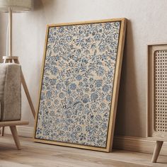 an ornate blue and white wall hanging next to a wooden frame in a living room