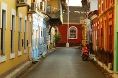 an alley way with buildings and a scooter parked on the sidewalk in front of it