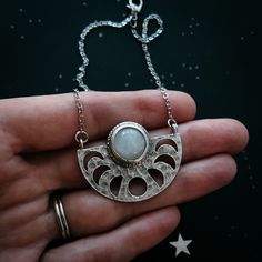 "Bring out your inner lunar Goddess and celebrate the feminine connection between us and our Moon. A beautiful brass pendant with phases of the Moon and set with a flashy piece of rainbow Moonstone. This necklace celebrates the mystery and majesty of our closest cosmic dance partner. A wonderful new age gift for the astrology lover. Pendant Size: 1 1/2\" x 1\" (4.7cm x 3.2cm) Chain Length: 18\" (40.5cm) Materials: rhodium plated brass, rainbow moonstone ★ These are individually handcrafted and t Spiritual Moon Phase Pendant Jewelry, Lunar Goddess, Cosmic Necklace, Handmade Moon-shaped Spiritual Necklace, Bohemian Moon-shaped Gemstone Necklace, Moon Accessories, Bohemian Moon-shaped Crystal Necklaces For Gift, Cosmic Dance, Cosmic Jewelry