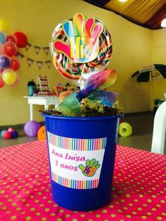 there is a potted plant with candy in it on top of a table at a birthday party