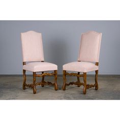 a pair of wooden chairs with pink upholstered seats