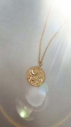 "This Night's Sky coin pendant is etched from original illustrations and is embellished with a tiny crescent Moon and tiny stars. Edged in delicate granulation, this is the perfect delicate gold necklace for layering. The necklace is made from sterling silver and is plated in 18ct yellow gold.  Width of coin: 1.8cm Length of chain: 18\" chain with an adjuster at 16\"" Gold Moon-shaped Engraved Necklace, Dainty Brass Moon Charm Necklace, Delicate Moon Charm Pendant Necklace, Celestial Crescent Charm Necklace With Delicate Chain, Delicate Moon Phase Charm Necklaces, Gold Engraved Moon Necklace, Delicate Moon Phase Charm Necklace, Gold Coin Pendant Necklace With Moon Charm, Gold Crescent Necklace With Coin Pendant