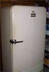 a white refrigerator sitting in a kitchen next to a shelf