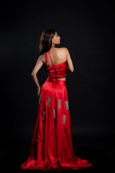 Adding a touch of royal elegance and grace to weddings and festivities, this stunning scarlet-red lehenga is a must-have! The cupro satin fabric is soft and lightweight, making it perfect for twirling around the dance floor. The intricate hand-embroidered mirror work adds a unique sparkle to your look.Details Neckline: Halter neck Material: Cupro satin Lining: Cotton-polyester Made in India Material This outfit is made with cupro satin; the fabric is made from cotton linter wasteIt is a sustainable alternative to polyester Bollywood Style Silk Evening Sets, Festive Satin Pre-draped Saree For Formal Occasions, Traditional Satin Pre-draped Saree For Evening, Silk Sharara For Evening And Diwali, Silk Sharara For Diwali Evening, Traditional Raw Silk Evening Set, Silk Lehenga With Zari Work For Party, Elegant Dola Silk Lehenga For Formal Occasions, Silk Anarkali Traditional Evening Wear