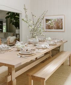 a dining room table is set with white dishes and place settings for two people to eat